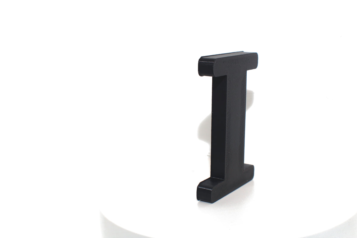 Black Eye large prop, matte black finish, standing on a white platform.