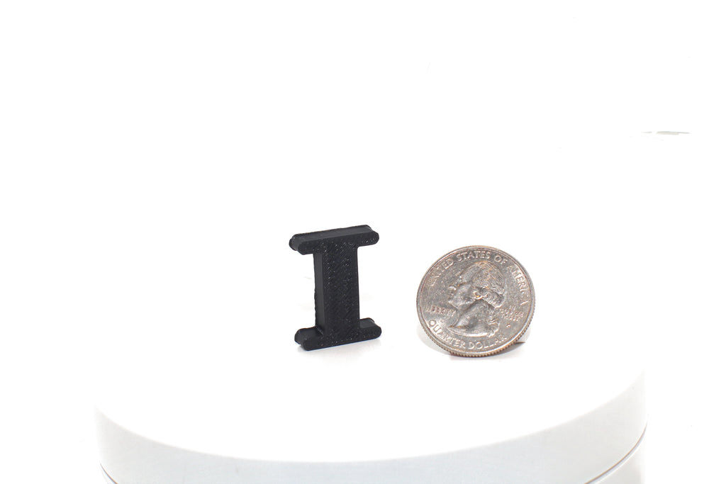 Black Eye pun prop, small size, shown beside a US quarter for scale.