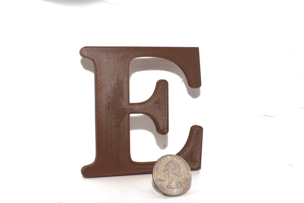 Brown E large prop shown beside a US quarter, highlighting the size difference.