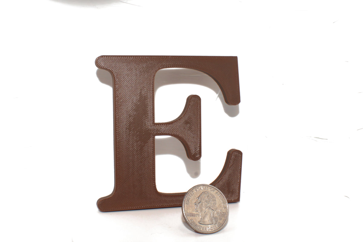 Brown E large prop shown beside a US quarter, highlighting the size difference.