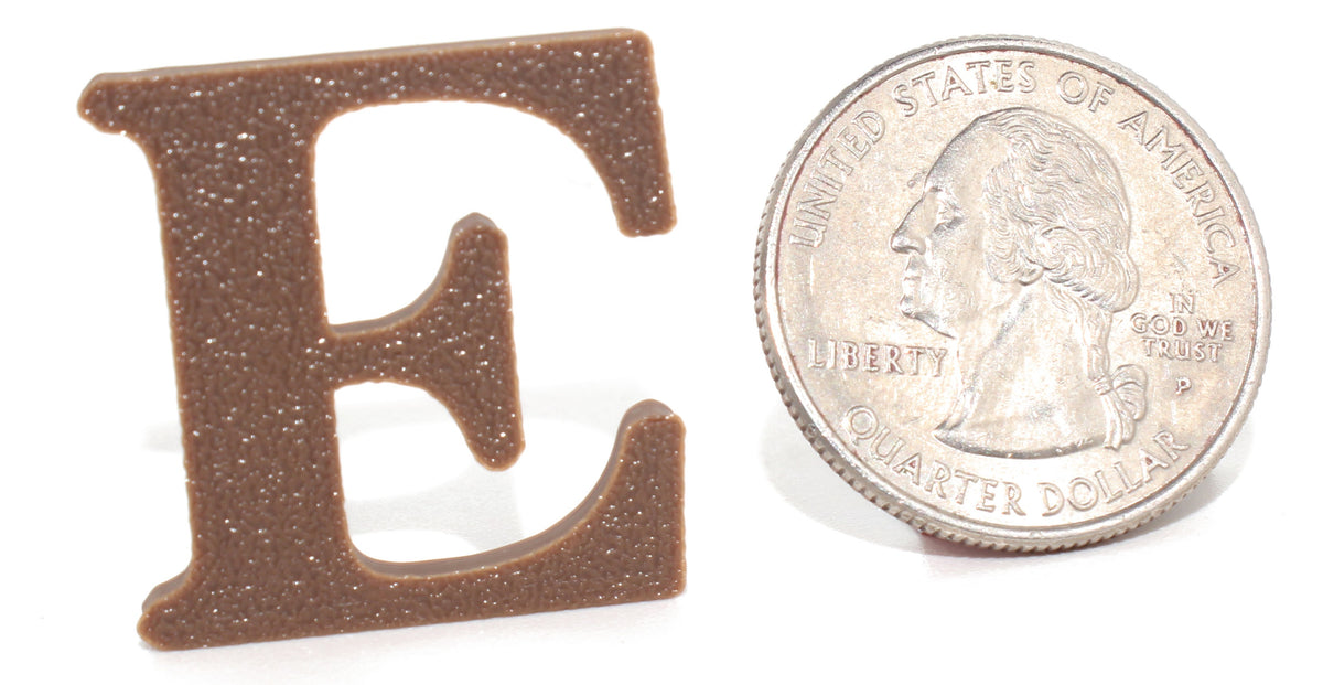 Brown E pun prop, small size, shown beside a US quarter for scale.