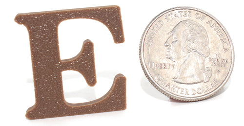 Brown E pun prop, small size, shown beside a US quarter for scale.