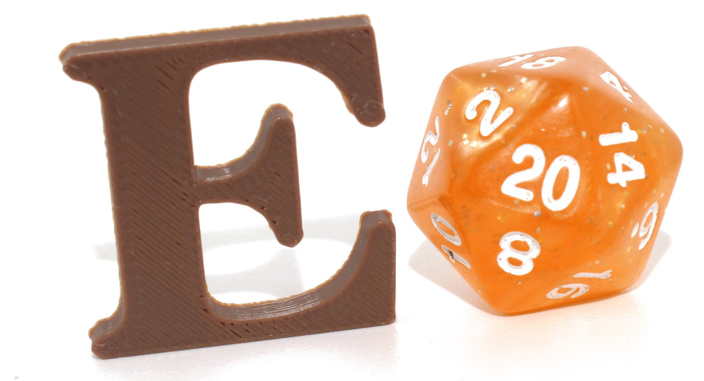 Brown E small prop next to an orange d20 die for size comparison.