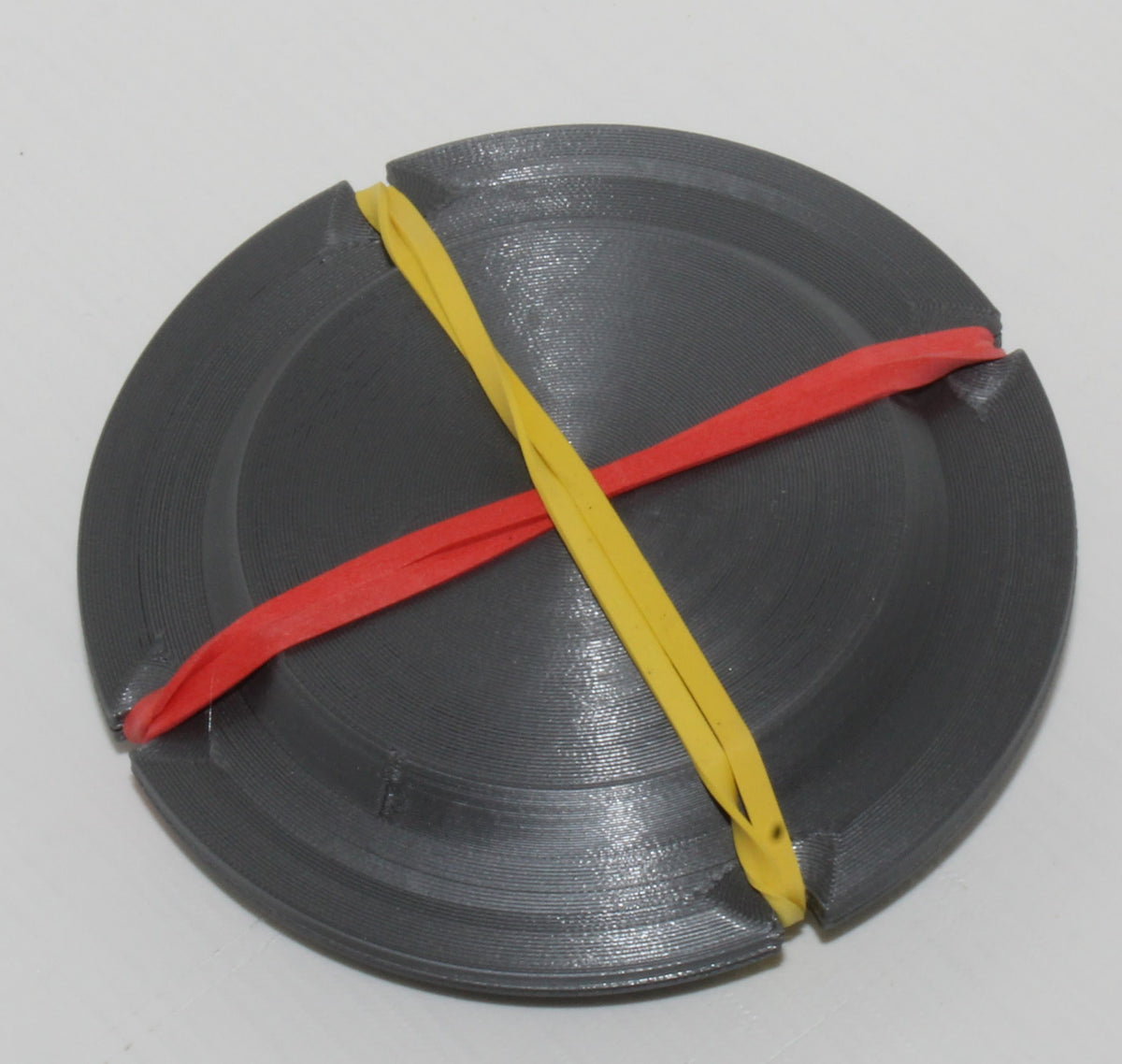 Jiffy Coin Trick prop, black 3D-printed coin holder shown with its retaining bands.