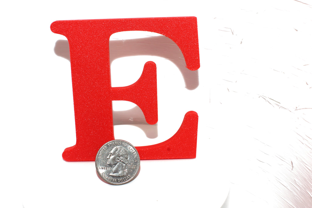 Red E large prop with a US quarter placed in front for size comparison.