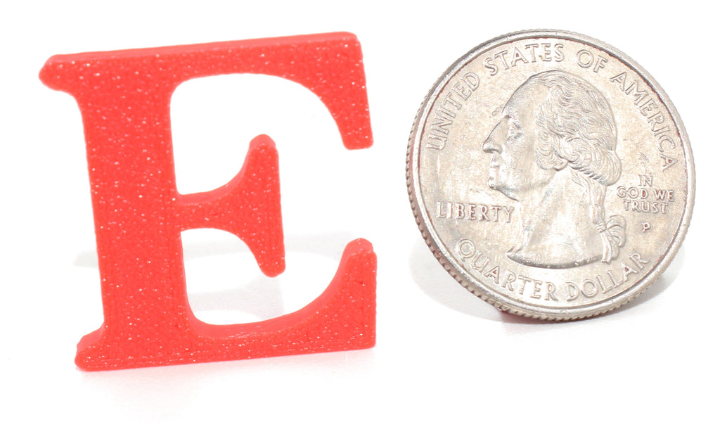 Red E pun prop, small size, shown beside a US quarter for scale.