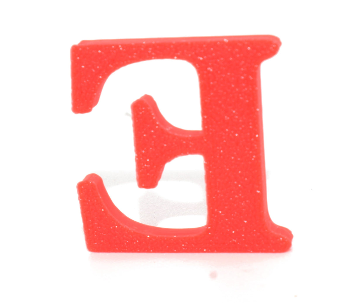 Red E small prop close-up, showing the glittery red finish.