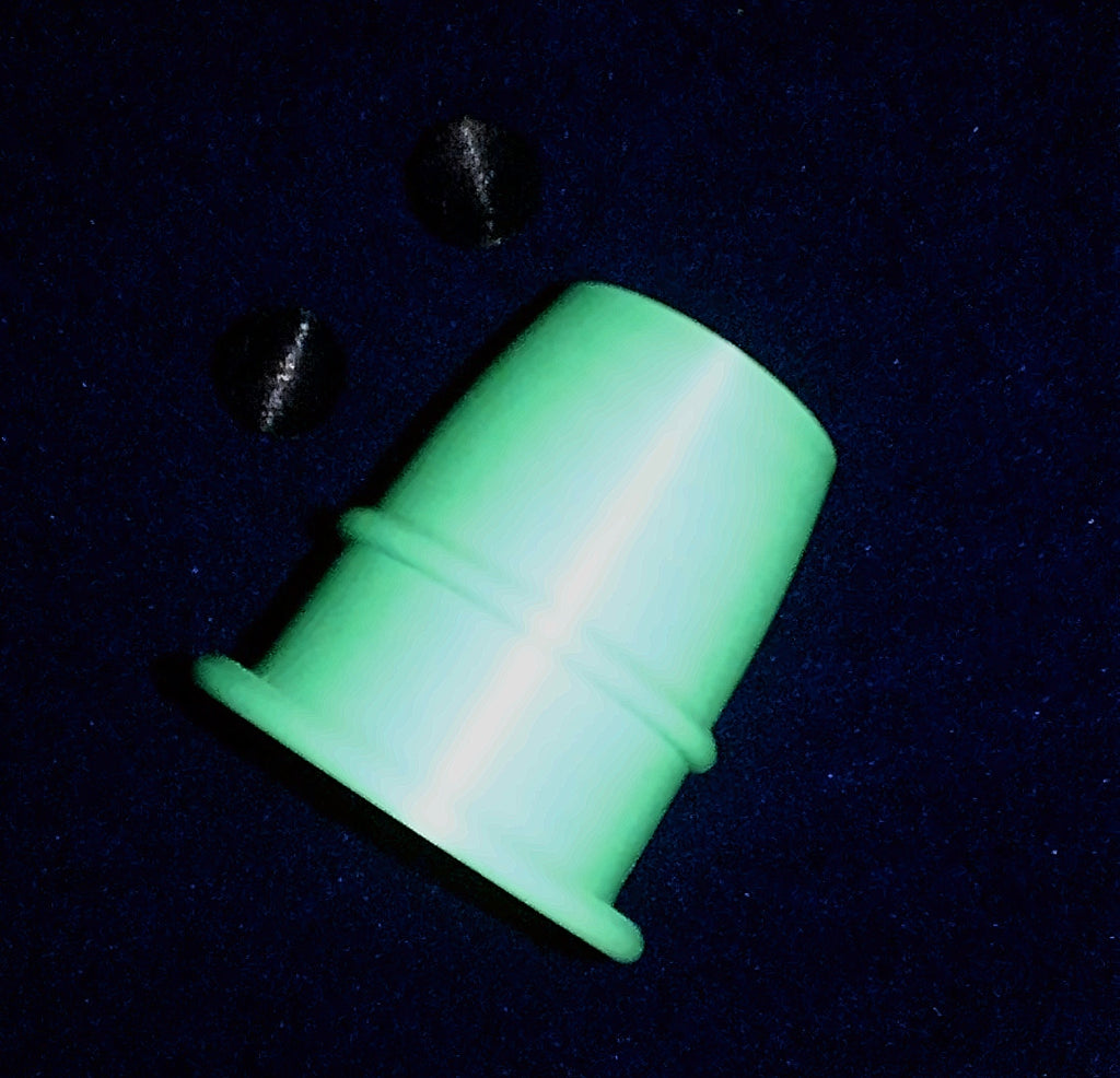 Green Q Family chop cup upside down on a dark mat with two black balls beside it